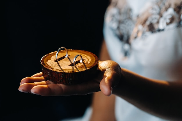 Gros plan de deux anneaux de mariage en or pour le mariage se trouvent sur la main.