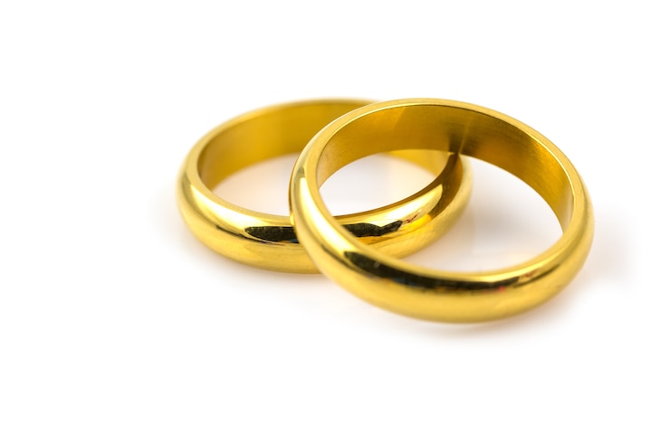 Photo gros plan de deux anneaux d'or pour mariage isolé sur fond blanc