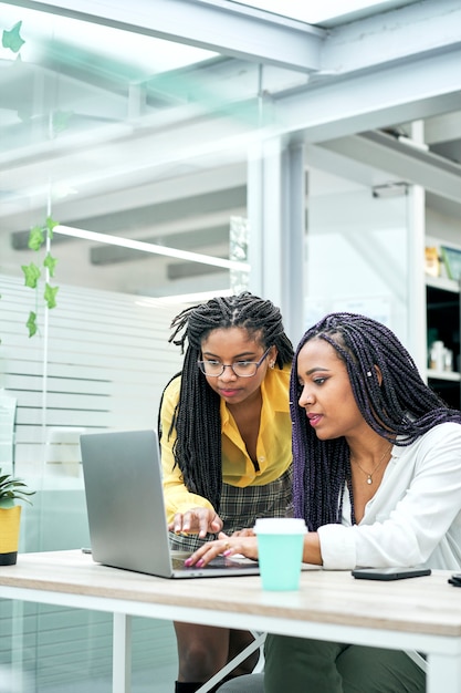 Gros plan de deux jeune femme d'affaires utilisant un ordinateur portable lors de la réunion