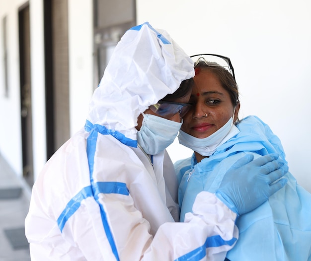 Gros plan de deux médecins indiens avec un uniforme médical se réconfortant sur fond blanc