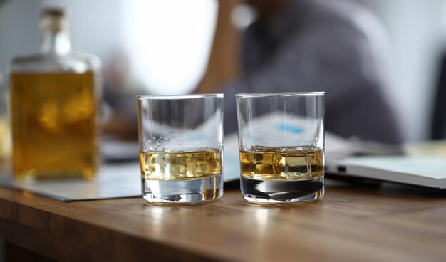 Gros plan de deux verres de boisson forte sur table en bois