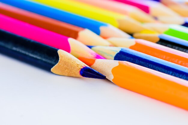 Gros plan différents crayons de couleur sur fond blanc.