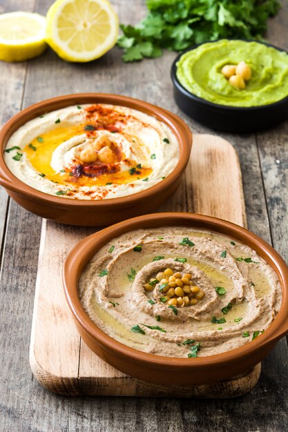 Gros plan sur divers houmous dans des bols avec des pois chiches et des lentilles