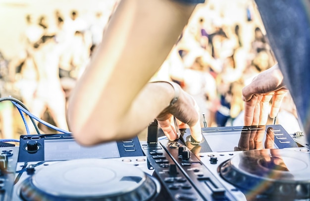 Gros plan de dj jouant du son électro sur un lecteur cd usb moderne à la fête de plage d'été
