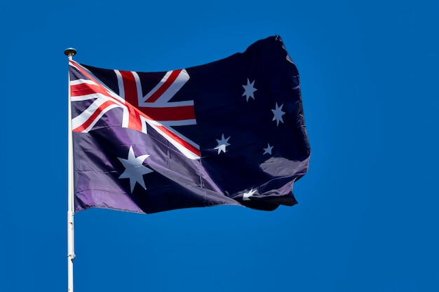 Gros plan sur le drapeau de l'Australie agitant au sommet de son mât
