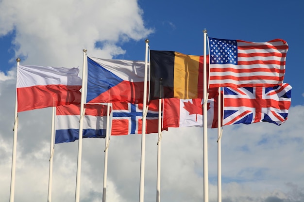 Photo gros plan des drapeaux internationaux agitant au sommet de leurs mâts