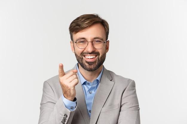 Gros plan du bel homme d'affaires avec barbe, portant un costume gris et des lunettes