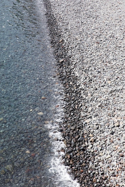 Gros plan du bord de l'eau sur la plage de galets