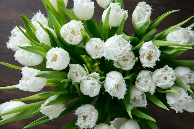 Gros plan du bouquet moderne de mode de différentes fleurs sur une surface en bois.