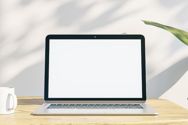 Gros plan du bureau de bureau de concepteur créatif avec écran d'ordinateur portable blanc vide avec lieu de maquette