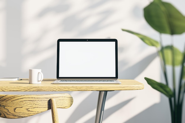 Gros plan du bureau de bureau de concepteur créatif avec écran d'ordinateur portable blanc vide