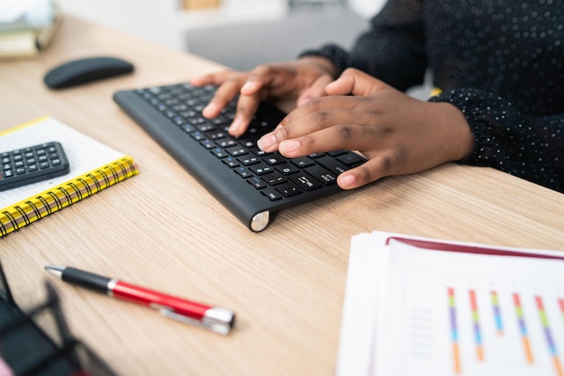 Gros plan du clavier noir de l'ordinateur debout sur un bureau en bois