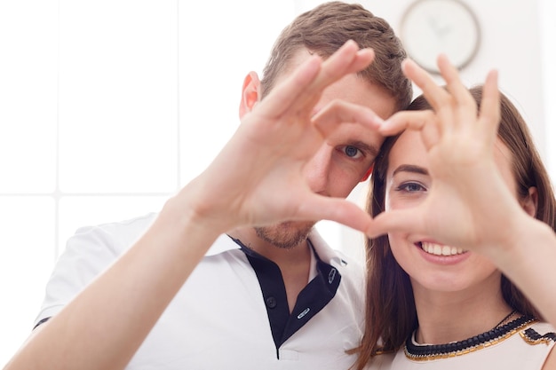 Photo gros plan du couple heureux en forme de coeur avec leurs mains. concept d'amour, de saint valentin et de relation, espace de copie