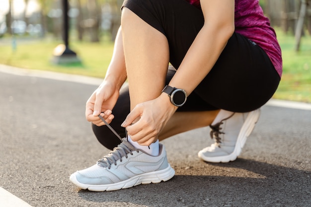 Gros plan du coureur de la jeune femme attachant ses lacets. concept sain et de remise en forme.