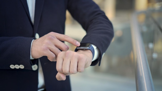 Gros plan du doigt de l'homme d'affaires glissant vers la gauche sur la smartwatch