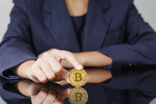 Gros plan du doigt touchant la pièce de monnaie bitcoin dorée Cryptocurrency et futur concept d'argent