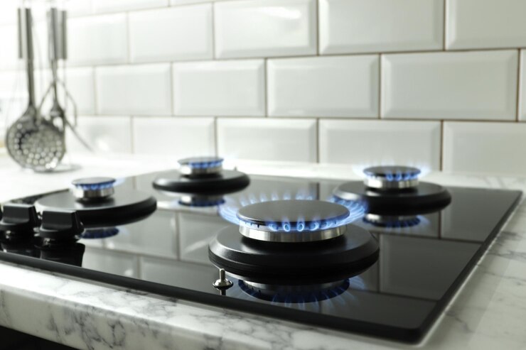 Gros plan du feu bleu de la cuisinière domestique. Cuisinière à gaz avec flammes brûlantes de gaz propane. Ressources industrielles et concept d'économie.