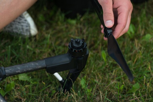 Photo gros plan du jeune ingénieur serrant l'hélice du drone uav avec outil à main dans le parc