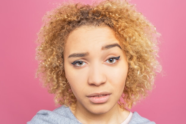 Photo gros plan du joli visage de la jeune fille. elle doute et elle est frustrée.