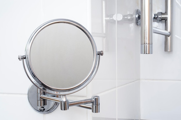 Gros plan du miroir rond avec de la vapeur sur la surface de la salle de bain