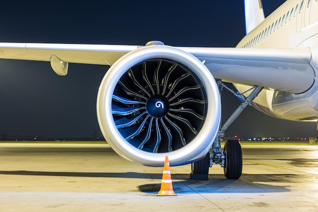 Gros plan du moteur du gros avion à réaction blanc de nuit