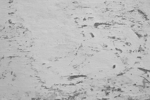 Gros plan du mur de fissure de ciment blanc et de la peinture décollée causée par l'eau et la lumière du soleil. Décollez le mur de peinture de la maison blanche avec une tache noire. Noir et blanc de fond de texture.