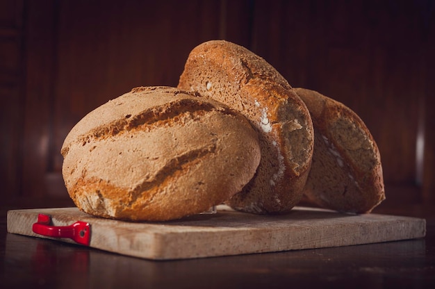 Un gros plan du pain sur la planche à découper