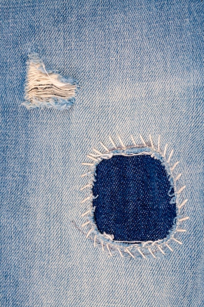 Gros plan du patch jeans vierge sur le côté intérieur du denim bleu usé