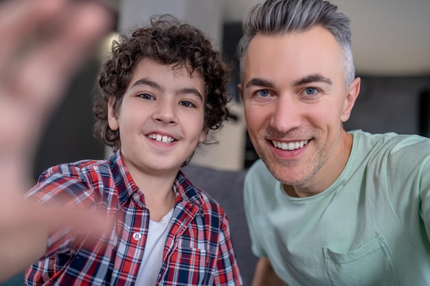 Gros plan du père avec son fils souriant à la caméra