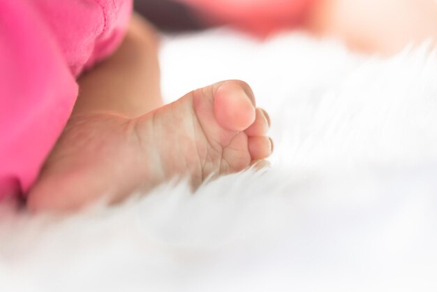 Gros plan du pied d'un bébé asiatique sur un tapis blanc en laine mise au point sélective