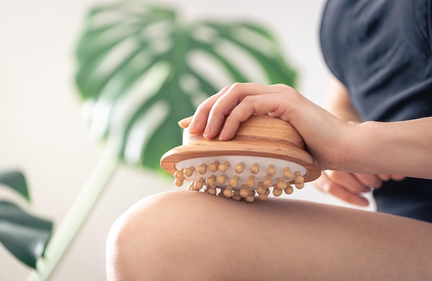 Gros plan du pinceau de massage anticellulite dans les mains des femmes