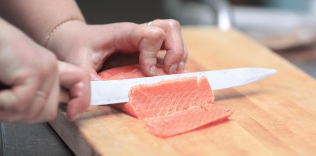 Gros plan du poisson en tranches de chef pour sushi