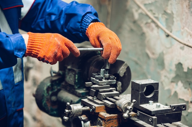 Gros plan du réparateur en uniforme, constructeur professionnel travaillant à l'aide d'équipement de construction. Processus de construction, rénovation d'appartement, réparation, construction. Scier, raccorder, couper, préparer.