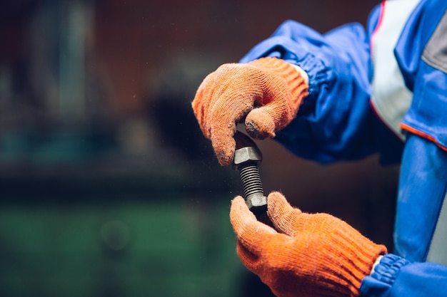 Gros plan du réparateur en uniforme, constructeur professionnel travaillant à l'aide d'équipement de construction. Processus de construction, rénovation d'appartement, réparation, construction. Scier, raccorder, couper, préparer.