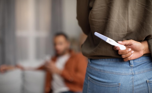 Gros plan du test de grossesse dans les mains de Wife39s mari surprenant à l'intérieur