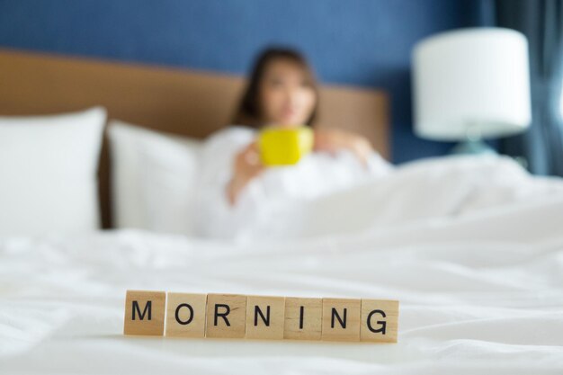 Photo en gros plan du texte du matin avec une femme en arrière-plan