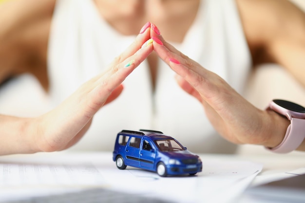 Photo gros plan du travailleur de l'assurance automobile couvrant le véhicule avec les mains de l'employé donnant la garantie