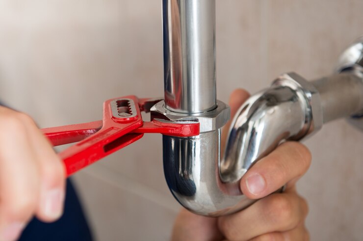 Gros plan du tuyau de fixation plombier avec clé