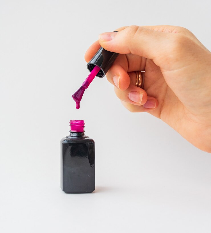 Photo gros plan du vernis à ongles rouge dans la main de