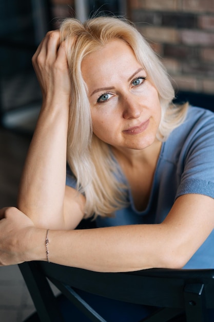 Gros plan du visage d'une femme blonde avec une peau parfaite regardant la caméra