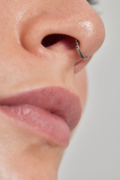 Gros plan du visage d'une jeune femme avec un septum perçant suspendu à son nez