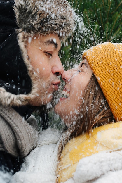 Gros plan du visage, portrait émotionnel, couple embrassant la neige tombe sur eux