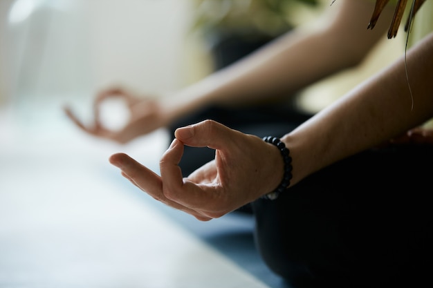 Photo gros plan du yoga mudra avec bras masculins, mains d'homme brillant faisant la méditation pose pour une concentration profonde