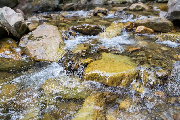 Gros plan de l'eau de montagne avec des pierres dans les rapides de la rivière Rivermountain avec de l'eau rapide et de gros rochers rocheux dans l'eau et les rochers massifs