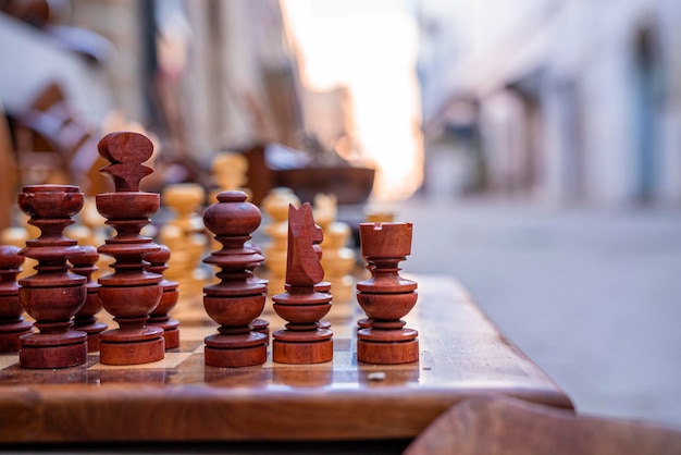 Gros plan sur un échiquier avec des pièces d'échecs sur le côté de la rue de la ville, un échiquier extérieur avec des figures en bois