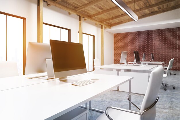 Photo gros plan d'un écran d'ordinateur debout dans un bureau avec des murs en briques et blancs et un plafond en bois. rendu 3d. maquette. image tonique