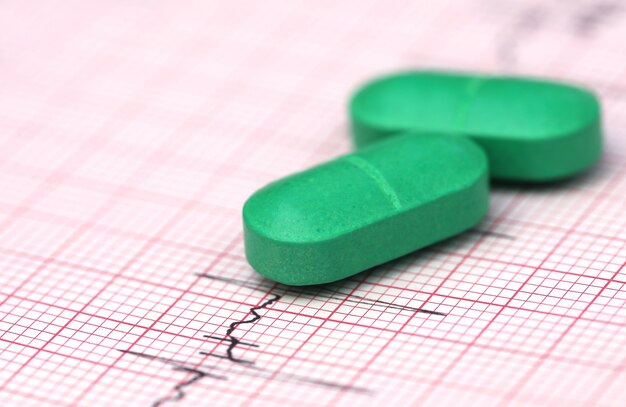 Gros plan de l'électrocardiographe avec des pilules