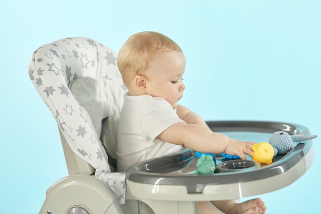 Gros plan d'un enfant assis sur une chaise haute et jouant avec des jouets