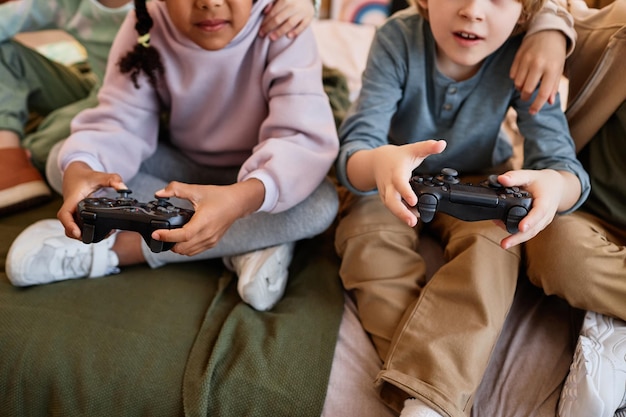 Gros plan d'enfants jouant à des jeux vidéo et tenant des contrôleurs