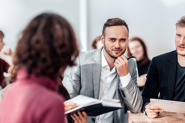 Gros plan sur l'entrepreneur maussade assis au bureau